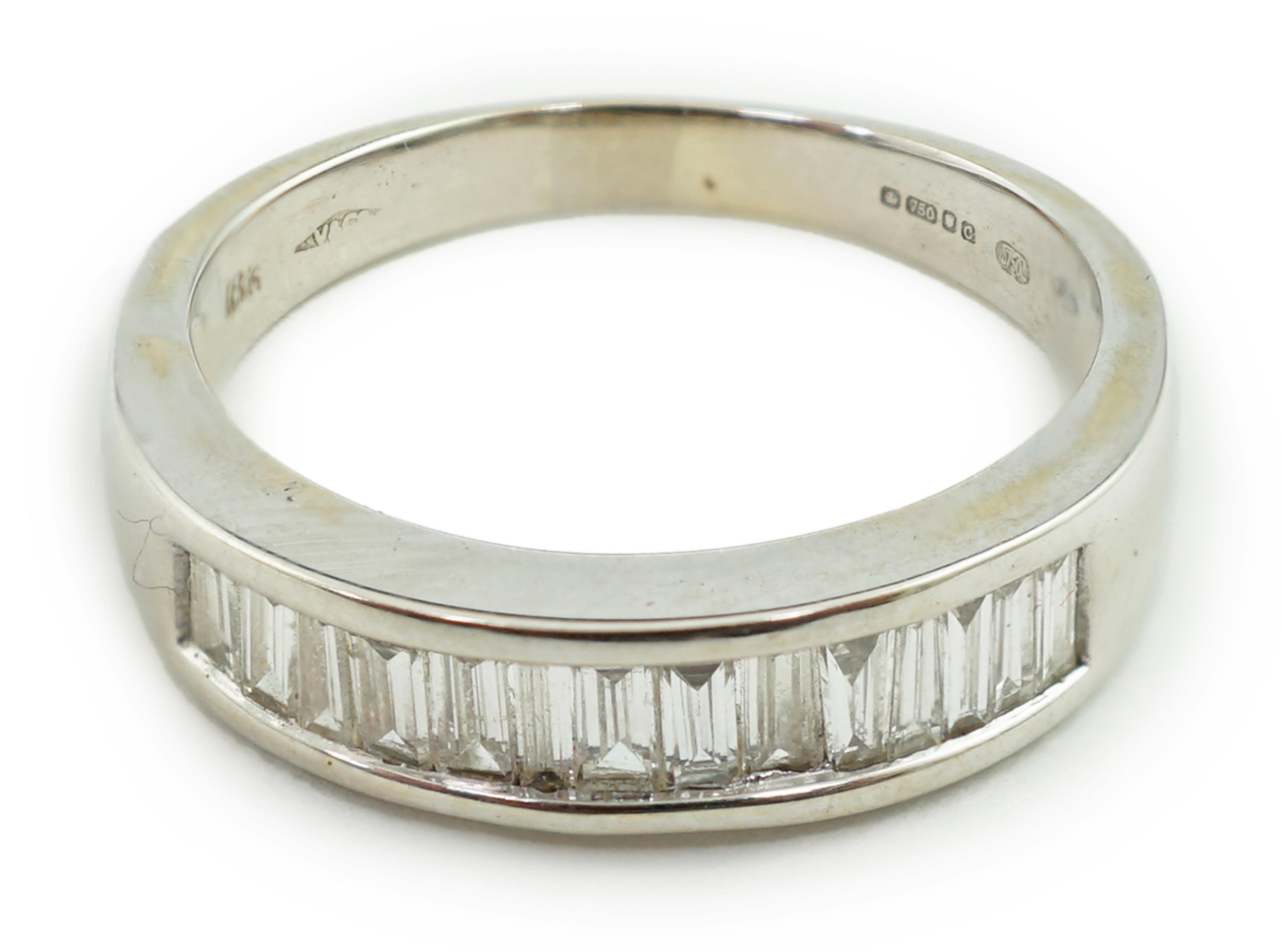 An 18ct white gold and baguette cut diamond channel set half eternity ring